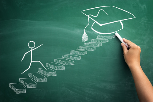 A chalk-board drawing of a stick-man running up stairs towards a graduation cap
